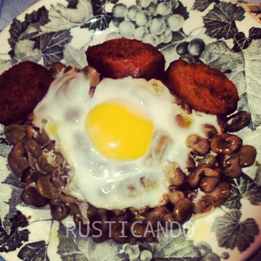 Un plato de huevos fritos con habas y pan mojado en grasa del chorizo. Comida de viña